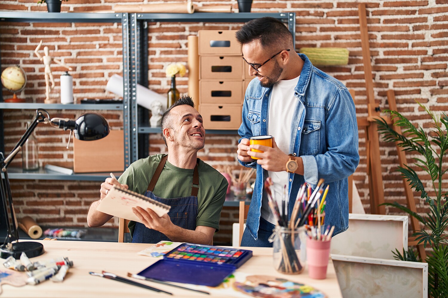 Two,Men,Artists,Drawing,On,Notebook,Drinking,Coffee,At,Art